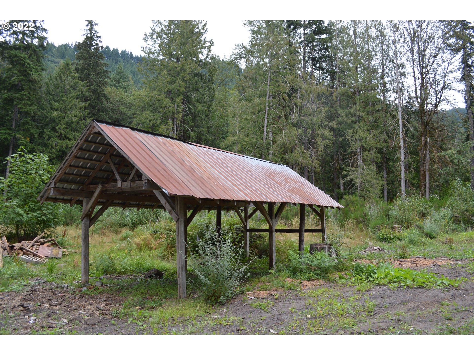 67193 East Barlow Trail Road Rhododendron, OR 97049 - Photo 10 of 19 a view of a barn with a yard potted plants and large tree