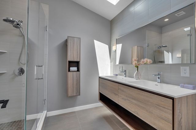 a bathroom with a double vanity sink mirror and shower