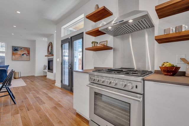 a kitchen with stainless steel appliances granite countertop a stove and a wooden floor