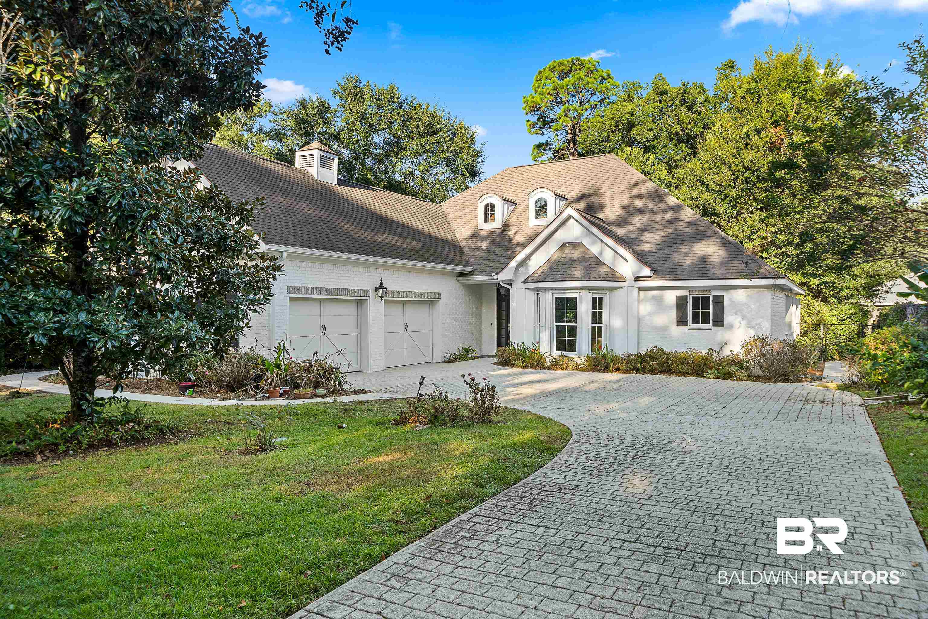 356 Liberty Street Fairhope, AL 36532 - Photo 2 of 39 View of front of house with decorative driveway, an attached garage, a front yard, a shingled roof, and stucco siding