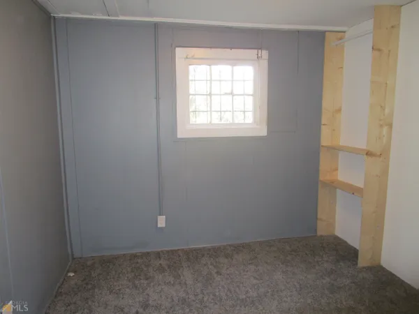 a view of a small space with wooden floor and a window