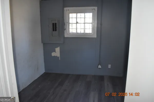an empty room with wooden floor and cabinet