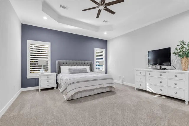 a spacious bedroom with a bed and a flat screen tv