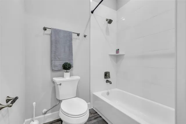 a white toilet sitting next to a bath tub