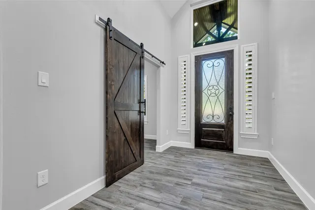 a view of a hallway with wooden floor and entryway