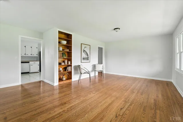a view of empty room with wooden floor and shoes