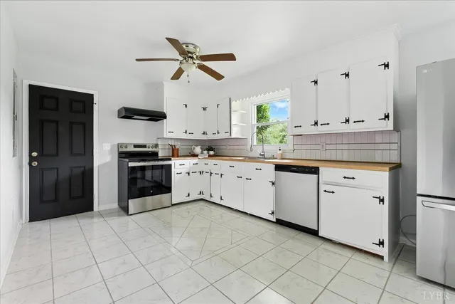 a kitchen with white cabinets and appliances