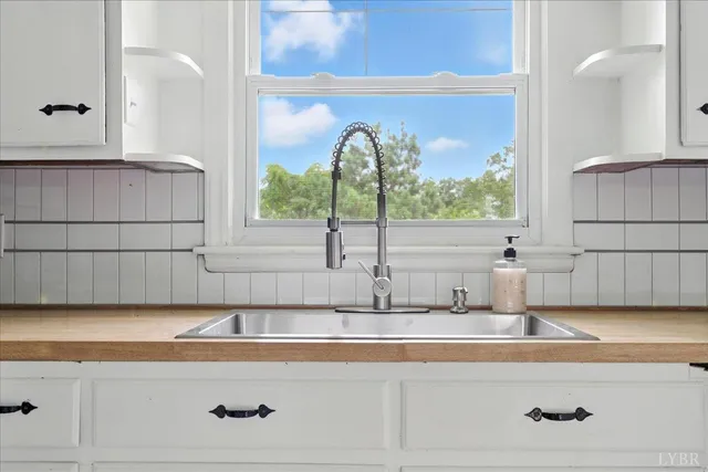 a kitchen with a sink and a large mirror