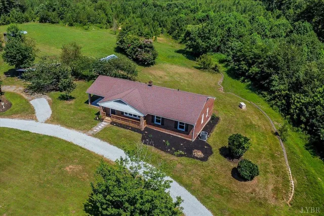 an aerial view of a house with swimming pool and a yard