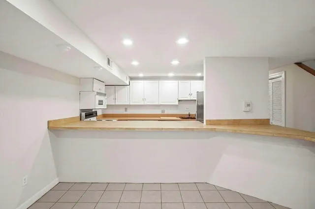 a view of open kitchen with kitchen island sink refrigerator and window