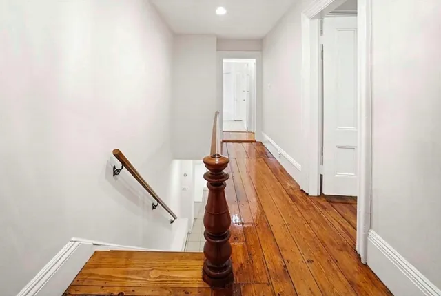 a room with wooden floor and pool table
