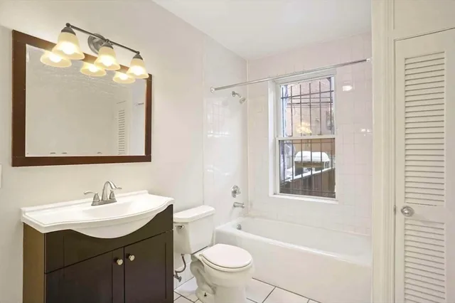 a bathroom with a sink a toilet a mirror a vanity and shower