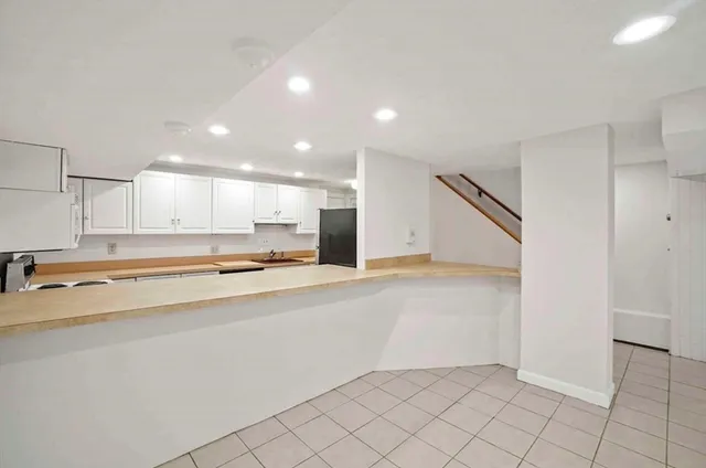 a view of kitchen with stainless steel appliances granite countertop a refrigerator and a sink