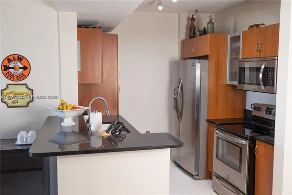 a kitchen with stainless steel appliances granite countertop a refrigerator and a microwave