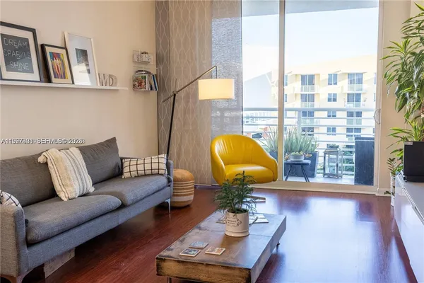 a living room with furniture a lamp and a large window