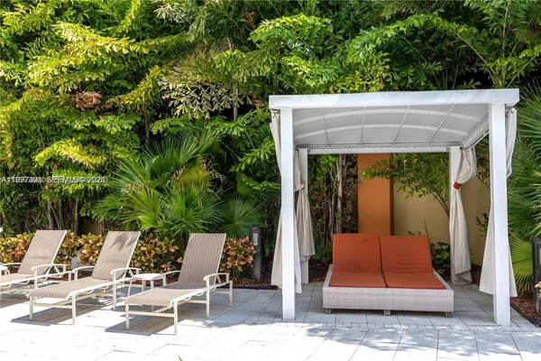 a view of a chairs and table in patio with a yard