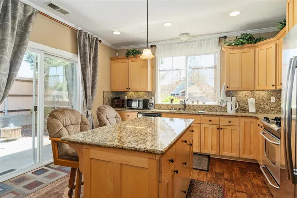 a kitchen with stainless steel appliances granite countertop sink stove and refrigerator