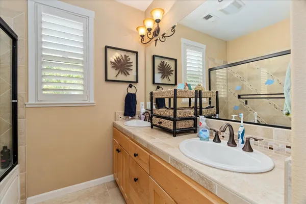 a bathroom with double vanity sink and a mirror