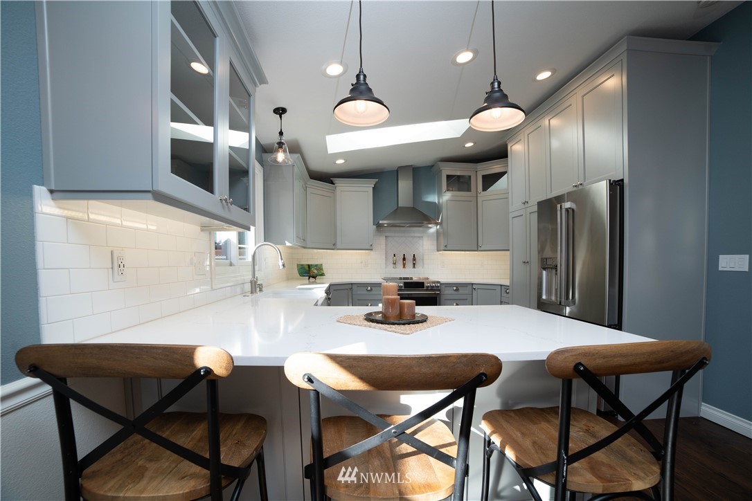 16714 3rd Avenue Southeast Bothell, WA 98012 - Photo 10 of 40 a kitchen with a dining table cabinets stainless steel appliances and a chandelier