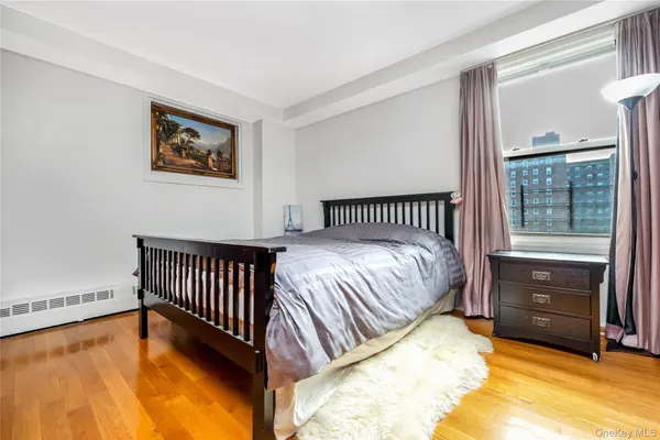 a bed sitting in a bedroom next to a window