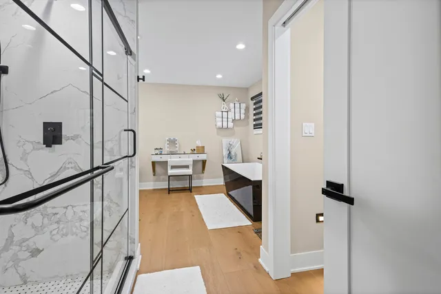 a dining room with kitchen island stainless steel appliances a sink and wooden floor