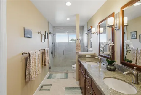 a bathroom with double vanity and a bathtub