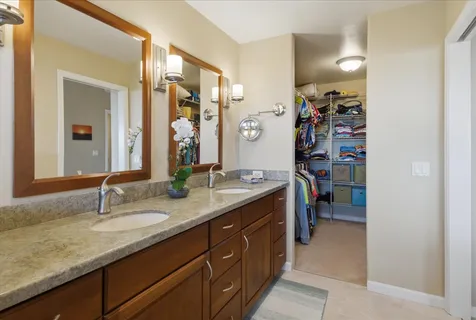 a en suite bathroom with a granite countertop sink and a mirror
