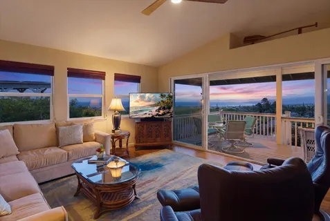 a living room with furniture a fireplace and a floor to ceiling window