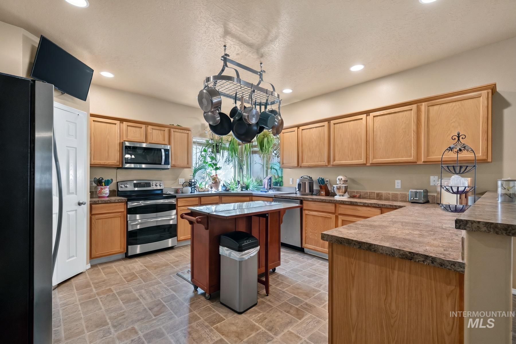 5020 Northrup Way Caldwell, ID 83607 - Photo 13 of 36 Functional kitchen with wood-finish cabinetry and ample counter space