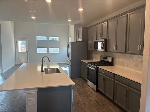 a kitchen with refrigerator and cabinets