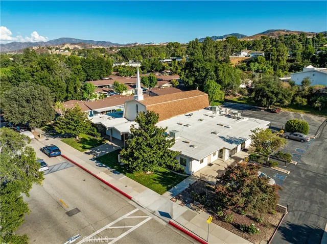 an aerial view of a house with a yard and mountain view in back