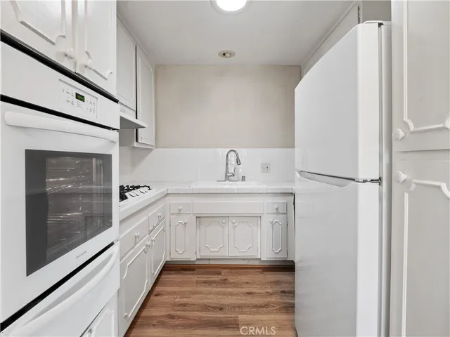 a kitchen with white cabinets and sink