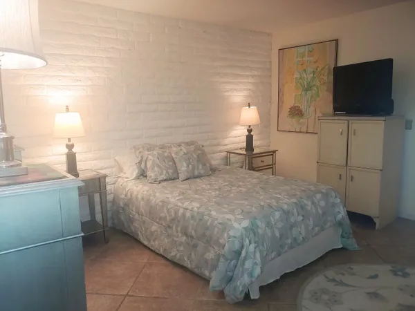 a bedroom with a bed and a flat screen tv