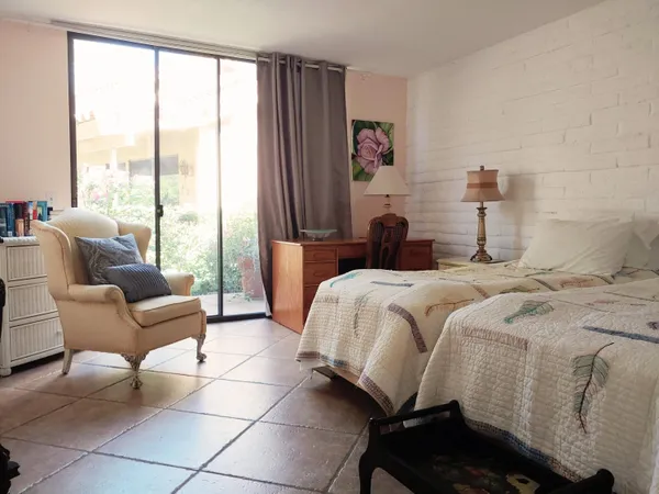 a bedroom with a bed and a couch next to a window