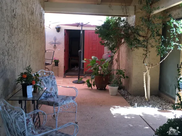 a view of backyard with outdoor seating and plants