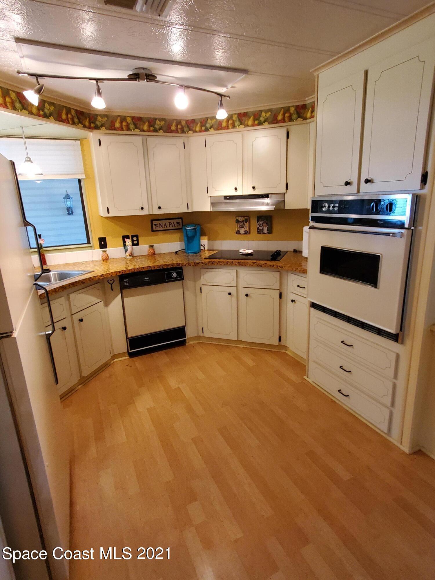 327 Macadamia Drive Sebastian, FL 32976 - Photo 13 of 31 a kitchen with a sink stove and cabinets