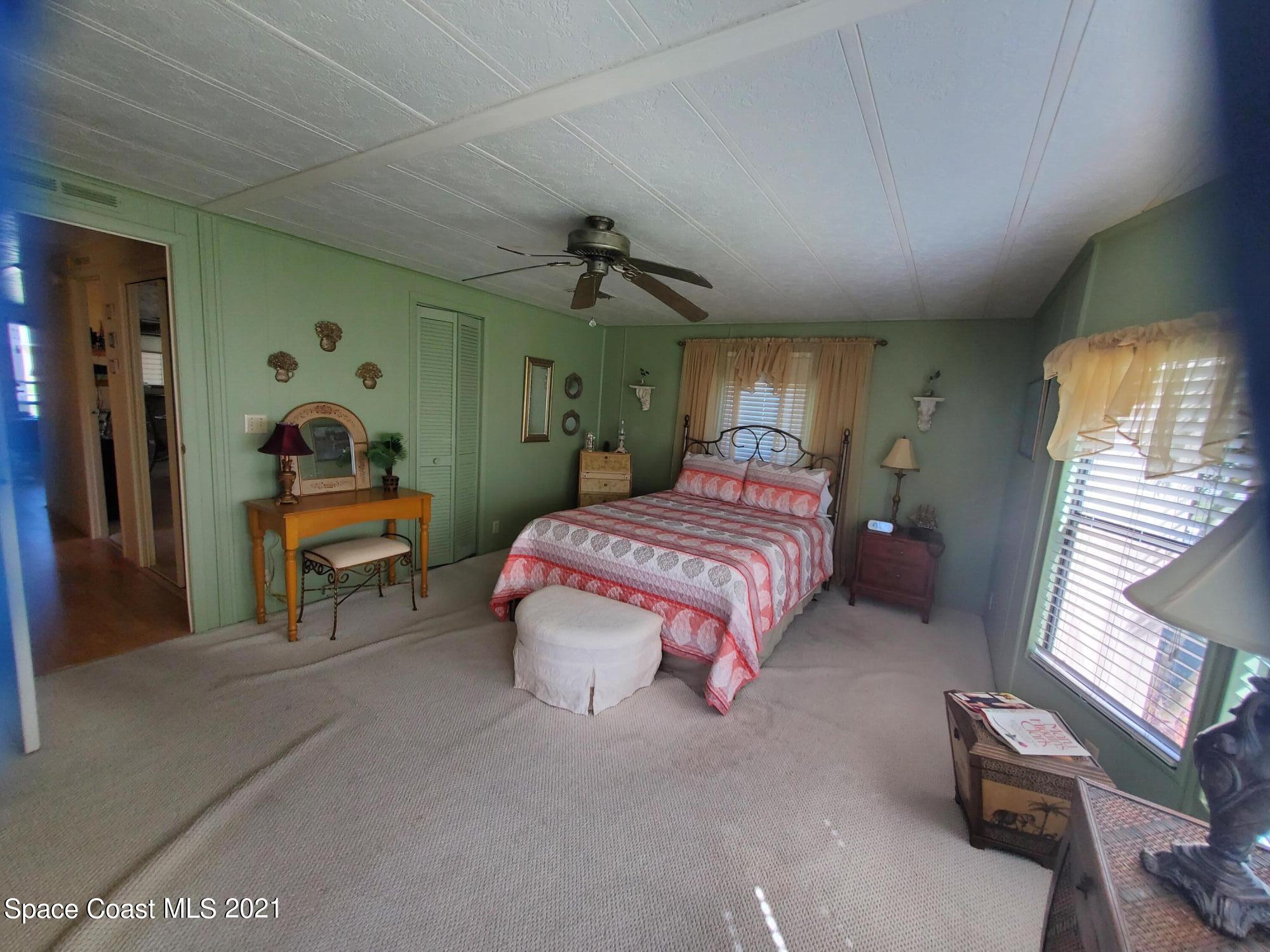327 Macadamia Drive Sebastian, FL 32976 - Photo 17 of 31 a bedroom with a bed and a chandelier