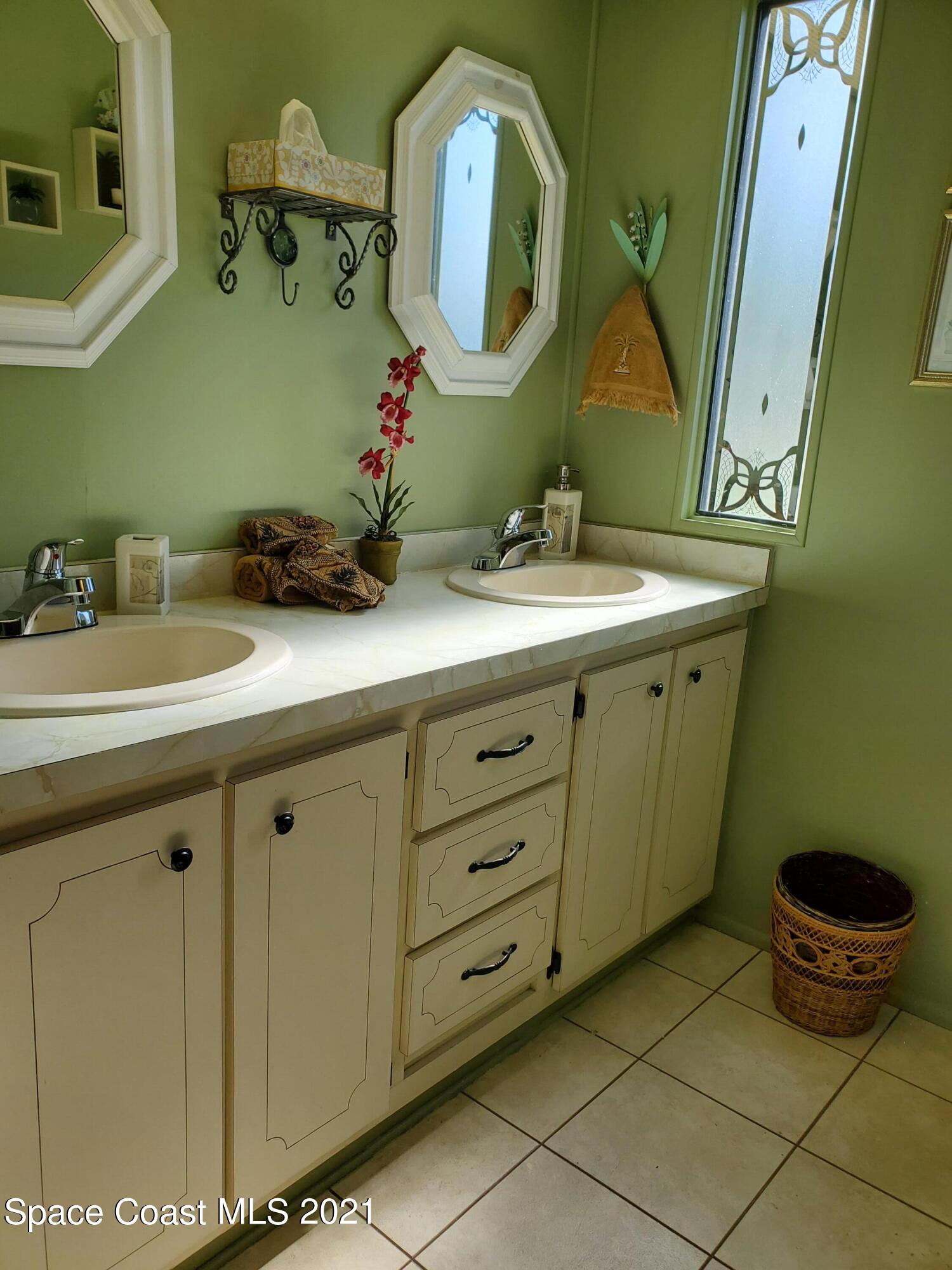 327 Macadamia Drive Sebastian, FL 32976 - Photo 21 of 31 a bathroom with a double vanity sink and a mirror