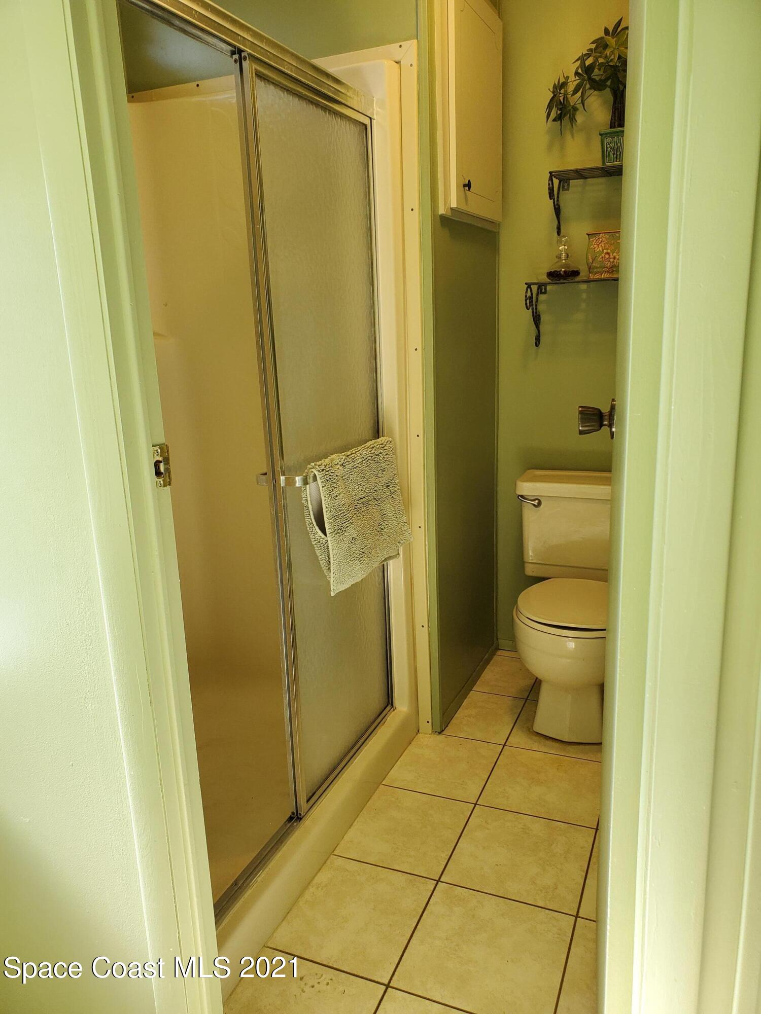 327 Macadamia Drive Sebastian, FL 32976 - Photo 22 of 31 a bathroom with a granite countertop shower and a toilet