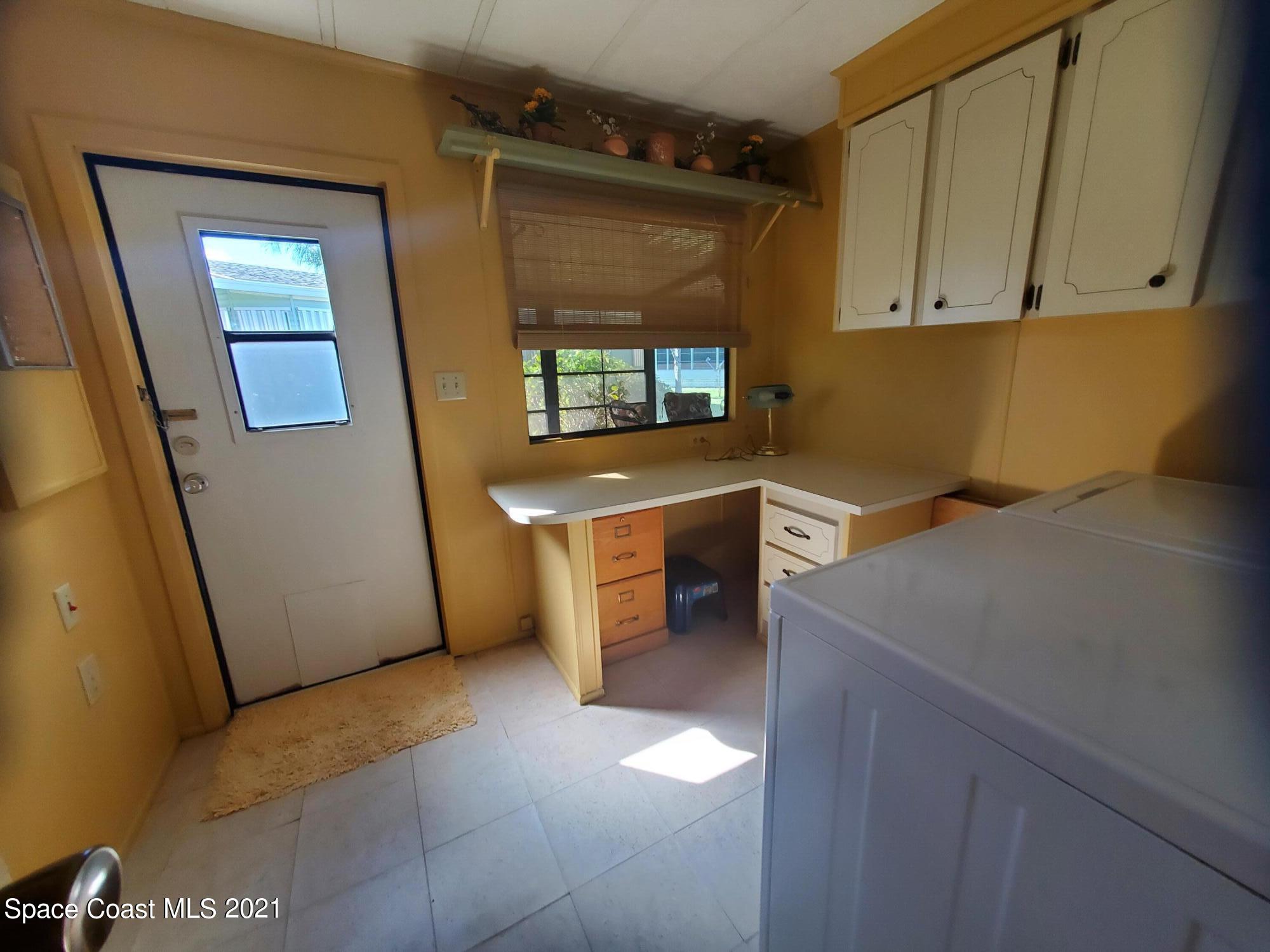 327 Macadamia Drive Sebastian, FL 32976 - Photo 25 of 31 a view of a kitchen with fridge and wooden floor