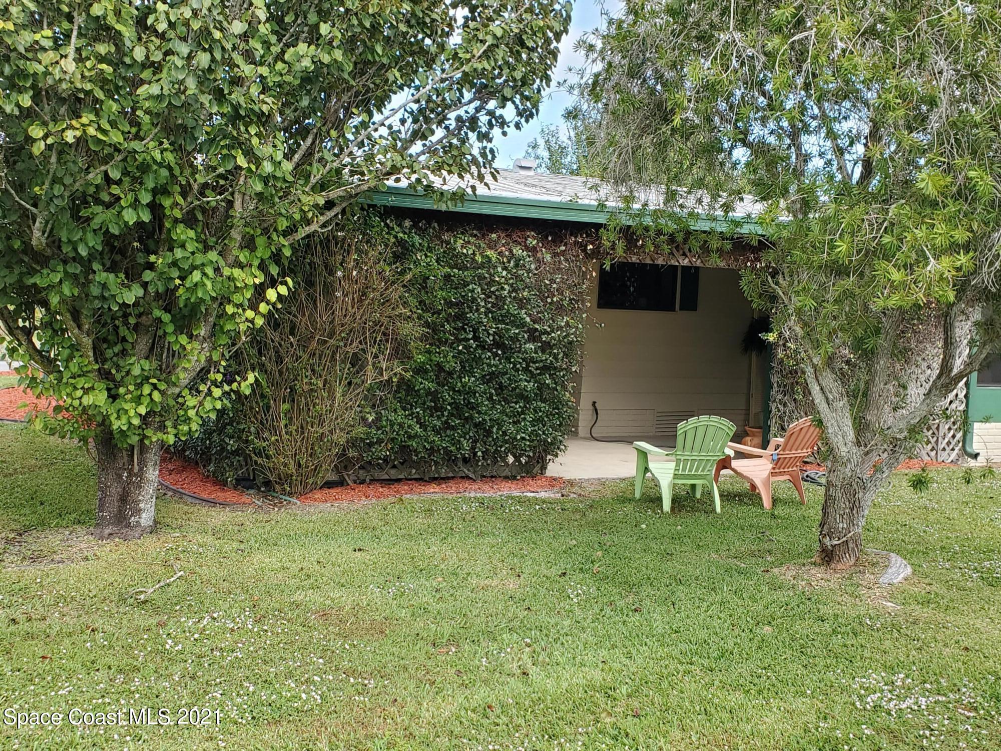 327 Macadamia Drive Sebastian, FL 32976 - Photo 30 of 31 a view of a backyard with table and chairs and a tree