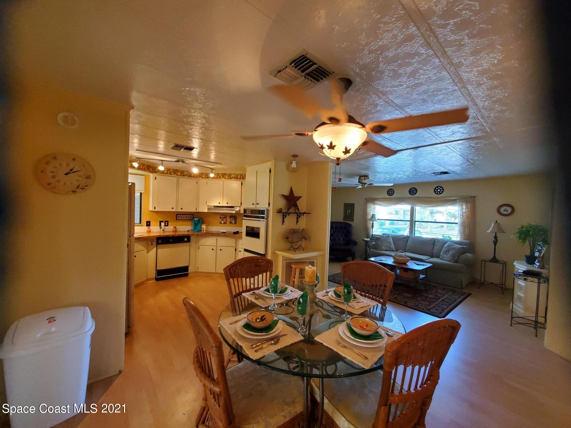327 Macadamia Drive Sebastian, FL 32976 - Photo 10 of 31 a living room with furniture a chandelier and a dining table