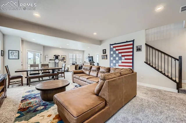 a living room with furniture a rug and a table