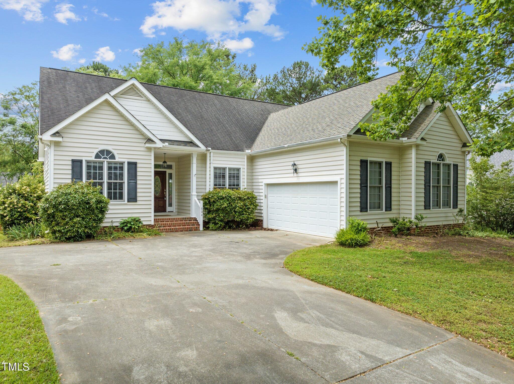 a view of a house with a yard and large tree