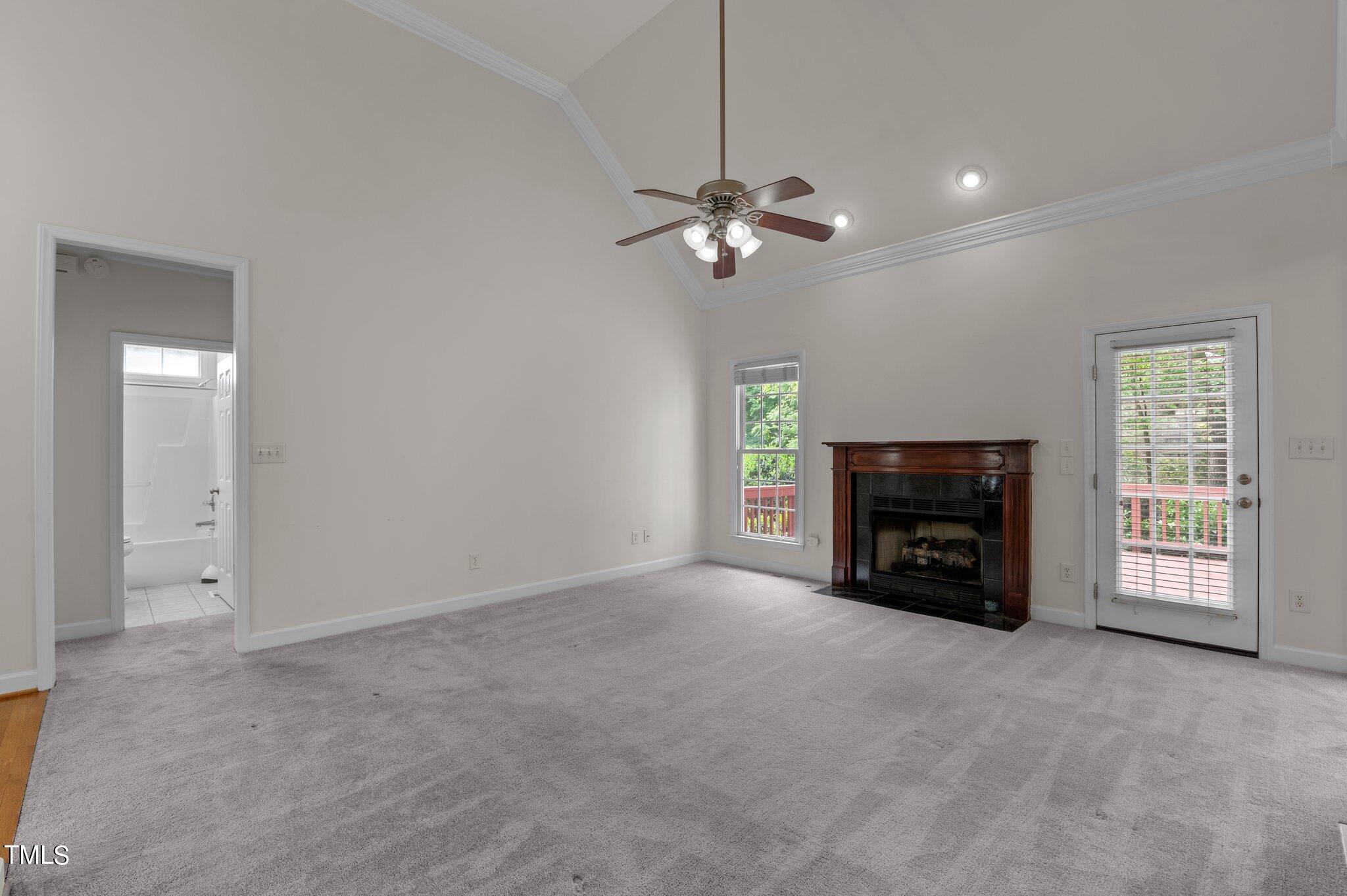 604 Middle Bridge Road Wake Forest, NC 27587 - Photo 10 of 48 a view of an empty room with a fireplace and a ceiling fan