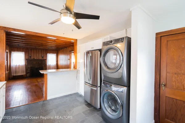 a view of washer and dryer with bathroom in the background