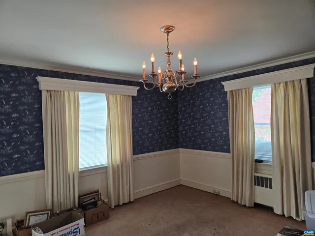 a view of a livingroom with a chandelier closet and windows