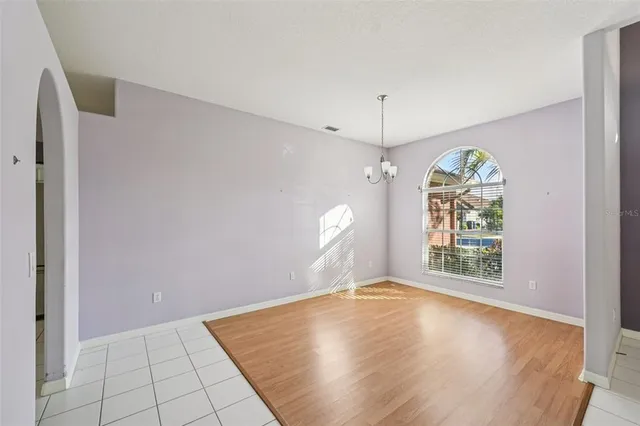 an empty room with windows and ceiling fan