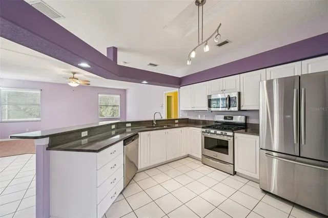 a kitchen with granite countertop stainless steel appliances and white cabinets