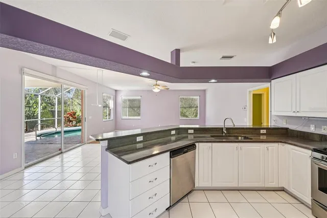 a kitchen with granite countertop a sink and white cabinets